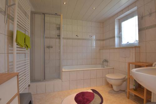 a bathroom with a tub and a toilet and a sink at Ferienhaus "Am Eisenberg"- Wandern im UNESCO Biosphärenreservat Vessertal in Schmiedefeld am Rennsteig