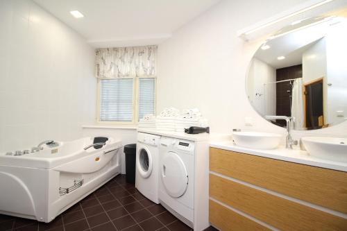 een badkamer met een wasmachine en een wastafel bij Tallinn City Apartments 4 bedroom with sauna and 2 bathroom in Tallinn