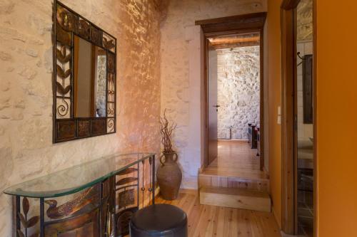 a hallway with a mirror and a glass table at Arcus Suites in Argyroupolis