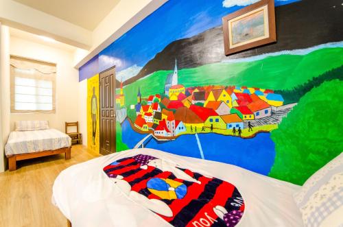 a bedroom with a mural on the wall at 响銅鑼民宿 in Tongluo