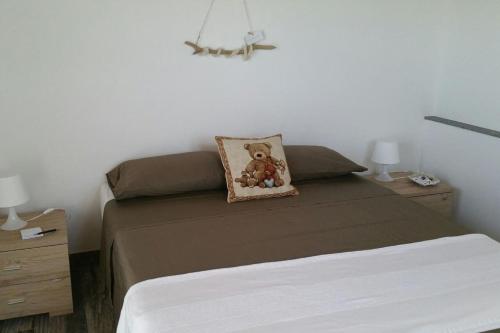 a bedroom with a bed with a teddy bear pillow at Casale dei Lamponi a "le Moline" vita in fattoria in Vetralla