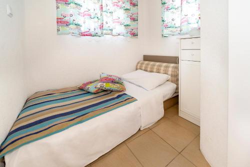 - une petite chambre avec un lit et une armoire dans l'établissement Camp Mali bungalow, à Baška