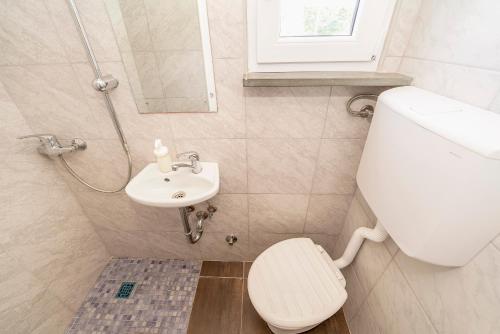 een badkamer met een toilet en een wastafel bij Camp Mali bungalow in Baška