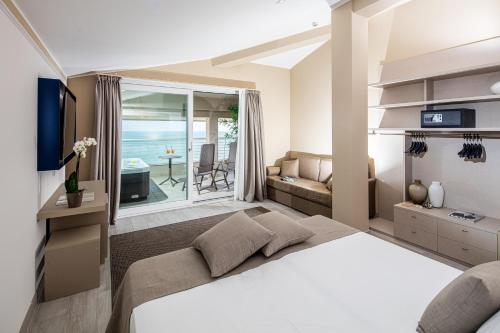 ein Schlafzimmer mit einem Bett und ein Wohnzimmer in der Unterkunft Hotel Capitol in Lido di Jesolo