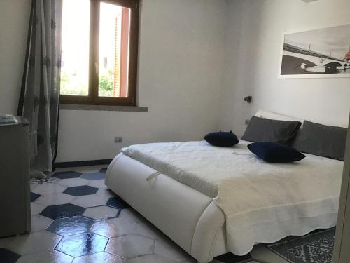a bedroom with a bed with blue pillows on it at Suites de Mar in Santa Teresa Gallura