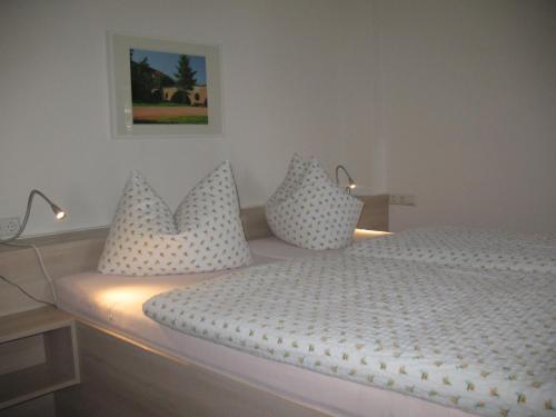 a bedroom with a white bed with pillows on it at Pension Hinz & Kunz in Weimar