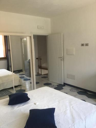 a bedroom with a large white bed and a mirror at Suites de Mar in Santa Teresa Gallura