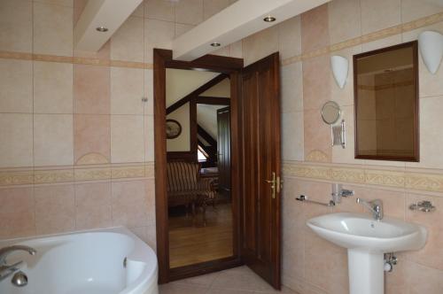 a bathroom with a tub and a sink and a mirror at Apartment 1925 in Palanga