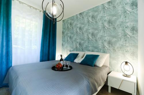 a bedroom with a bed with blue drapes at M&K Apartamenty - Morska Bryza, Sobieszewo- Wyspa Sobieszewwska in Gdańsk