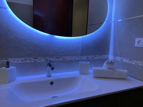 a bathroom with a white sink with a blue light at Acquamarina in Gaeta