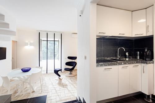 ナポリにあるTorre dell'incantesimoの白いキャビネット、テーブルと椅子付きのキッチンが備わります。