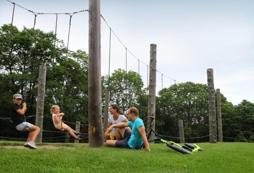 a group of people sitting on the grass at Apartmány na hájovně in Jeseník
