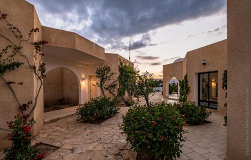 um edifício com um pátio com plantas e flores em Hotel Cercina em Ouled Yaneg