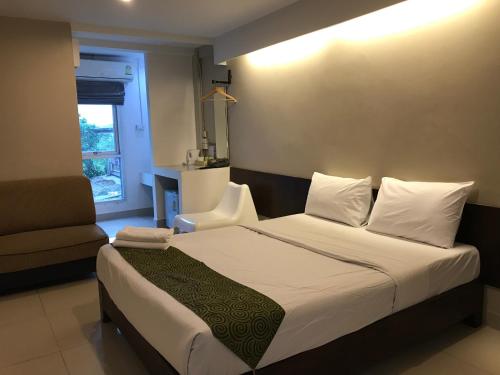 1 dormitorio con 1 cama con silla y ventana en L42 Hostel Suvarnabhumi Airport, en Lat Krabang