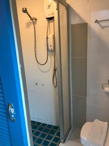 a shower stall with a toilet and a shower curtain at L42 Hostel Suvarnabhumi Airport in Lat Krabang