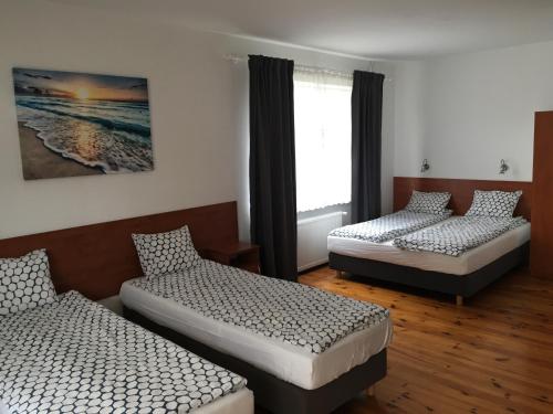 a room with three beds and a window at Pokoje Gościnne Wiola in Władysławowo