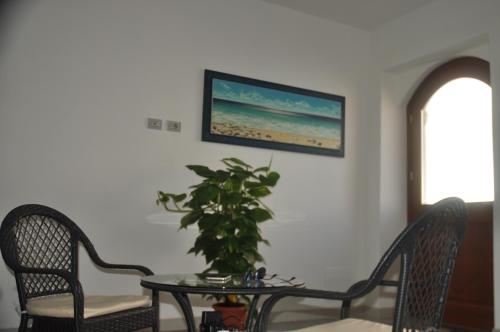 a table with a plant on it in a room at Suites de Mar in Santa Teresa Gallura