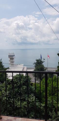 a balcony with a view of the ocean and a lighthouse at Yellow House - Vaja in Sarpi