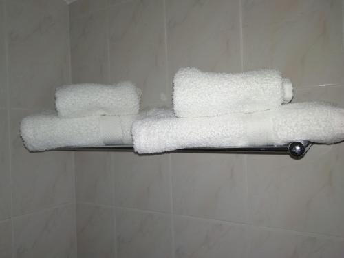 três toalhas num toalheiro na casa de banho em Rimavier Residence em Peniche