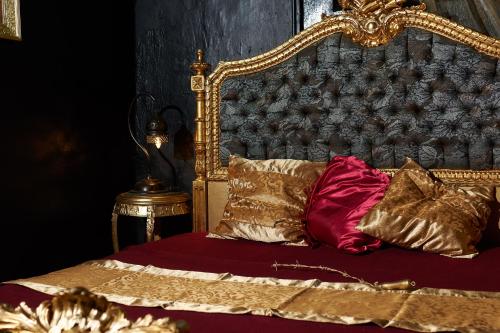 a bed with a gold frame and pillows on it at Karosta Prison in Liepāja