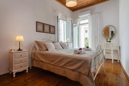 une chambre blanche avec un grand lit et une fenêtre dans l'établissement Diogenis Residence Euphoria, à Arménoi