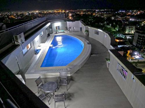 a swimming pool on top of a building at night at Residence Le Carat Bonapriso in Douala