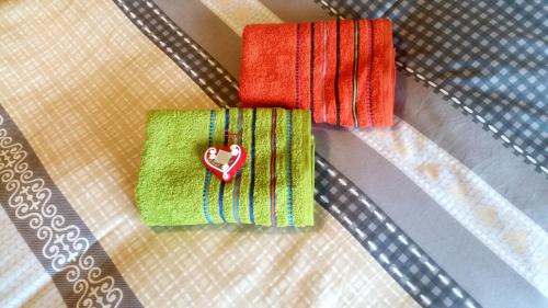 two towels with a heart on them on a table at Ethno Apartments in Ljubljana