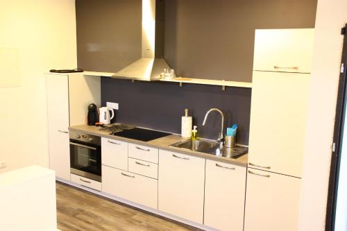 a kitchen with white cabinets and a sink at APARTMENTS 1A RIBNO - BLED in Bled