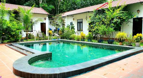 a swimming pool in front of a house at Hotel Thien Duong Xanh in Bình Chuẩn