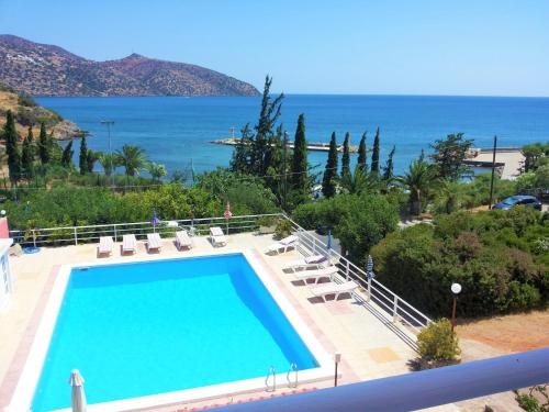 a swimming pool with the ocean in the background at Dimitra Apartments in Agios Nikolaos