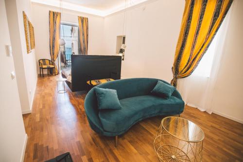 a living room with a green couch and a table at Suites of the Royal Council in Siracusa