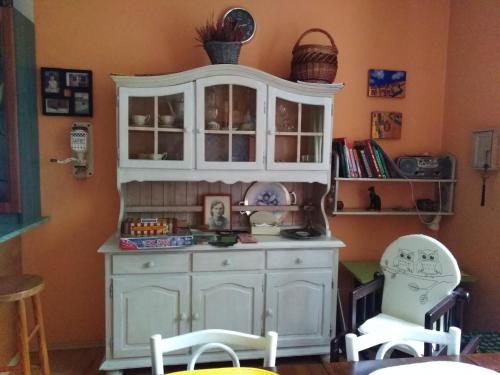 a kitchen with a white cabinet and two chairs at Pokoje Rodzinne Hanna in Gdańsk