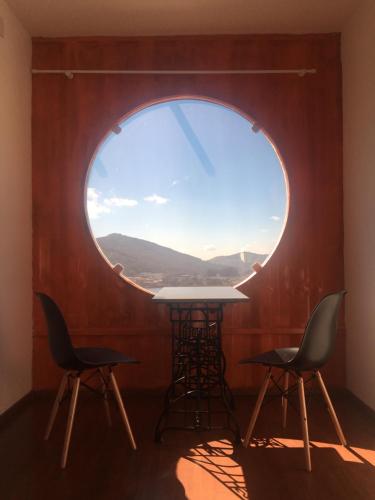 a table and chairs in a room with a round window at Amsterdam lofts 4 in Poços de Caldas
