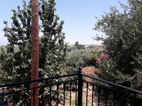 a balcony with a fence and a pole and trees at Monika Lefkada in Tsoukaladhes