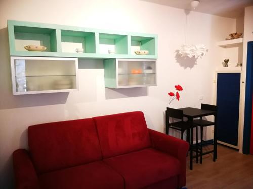 salon z czerwoną kanapą i stołem w obiekcie casa arcobaleno w mieście Isola del Giglio