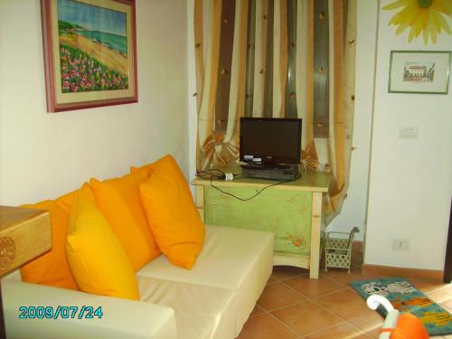 salon z białą kanapą z pomarańczowymi poduszkami w obiekcie CASA PUTIFIGARI w mieście Putifigari