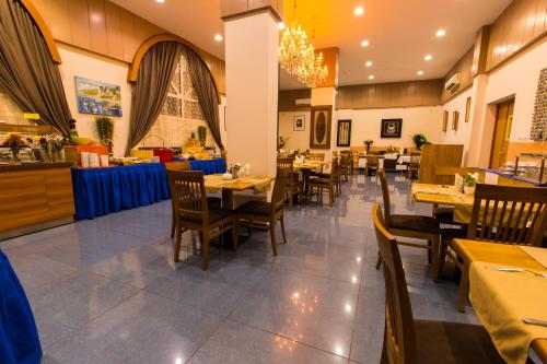 a dining room with tables and chairs in a restaurant at Atlantic Hotel in Djibouti
