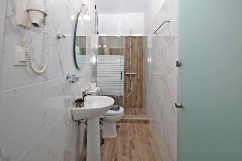a white bathroom with a toilet and a sink at Aqua Marine 2 in Neos Marmaras