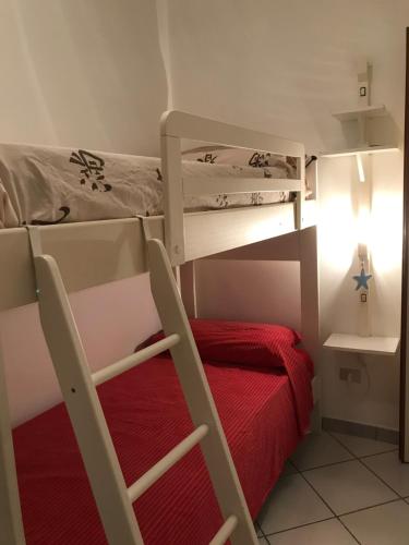 a bedroom with two bunk beds and a red bed at Villa Raffa Salento in Maruggio
