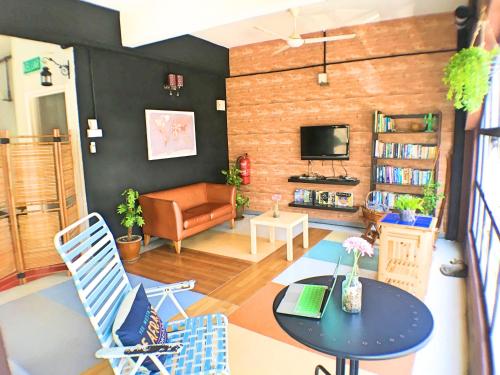 a living room with a couch and a table and chairs at Lavender@Guesthouse in Melaka