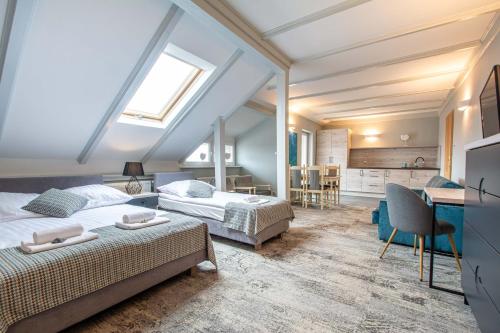 a attic bedroom with two beds and a desk at Villa Stawros in Łeba