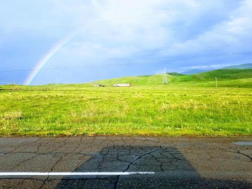 a rainbow in the sky over a field of grass at Karine B&B in Yeghegnadzor