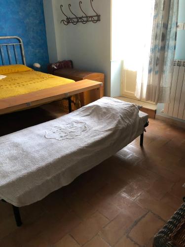 a bedroom with a bed and a table and a window at Casavacanze Ciaspole E Uva in Fiastra