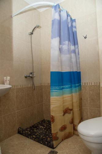 a shower in a bathroom with a shower curtain at Apart Lev in Ravda