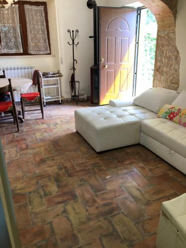 a living room with a couch and a door at Casavacanze Ciaspole E Uva in Fiastra