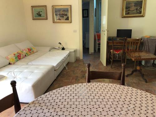 a living room with a white couch and a table at Casavacanze Ciaspole E Uva in Fiastra
