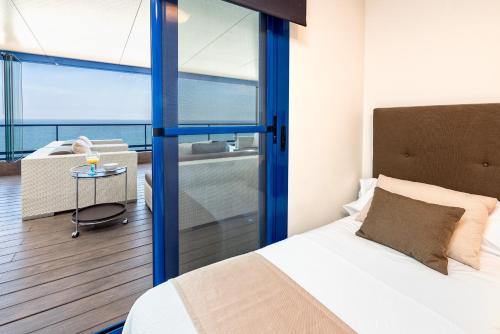ein Schlafzimmer mit einem Bett und einem Balkon in der Unterkunft iloftmalaga Ático Pacífico 19 A in Málaga