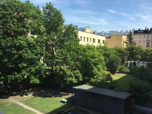 Vista de un patio con árboles y un edificio en Ullanlinna Studio, en Helsinki