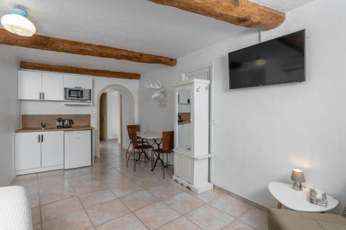 a kitchen and living room with a tv on the wall at Maison Carles BnB in La Colle-sur-Loup