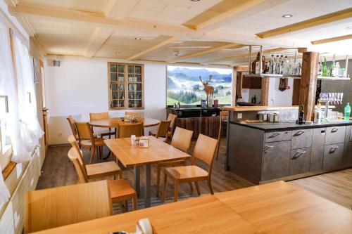 ein Restaurant mit Tischen und Stühlen und eine Küche in der Unterkunft Hirschen Eggiwil in Eggiwil